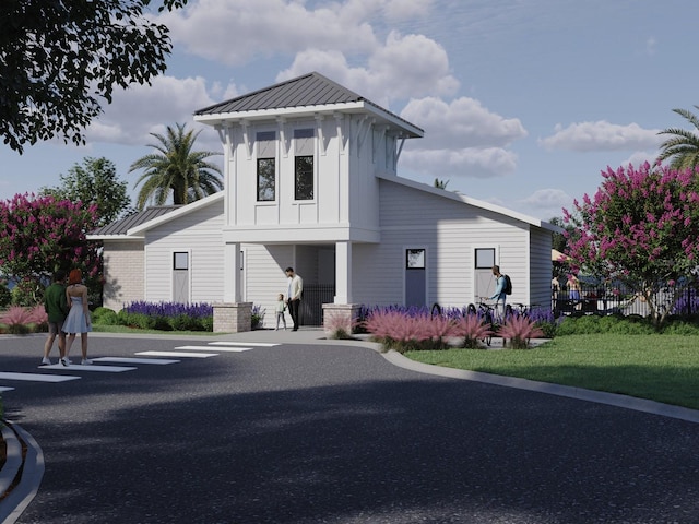 view of front of home with board and batten siding, fence, a standing seam roof, and metal roof