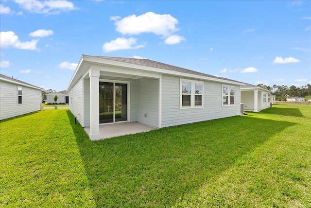 back of property with a patio and a yard