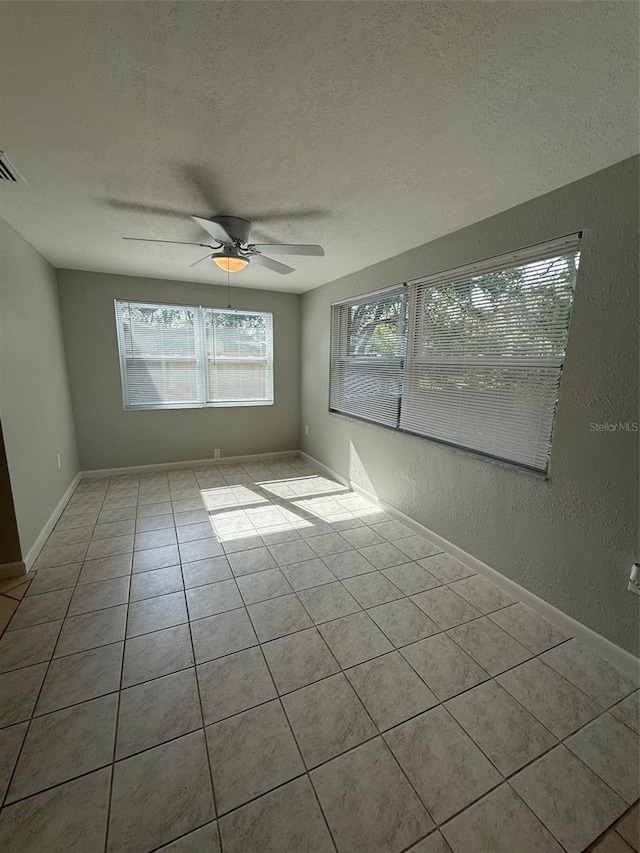 spare room featuring light tile patterned floors, a textured ceiling, and ceiling fan