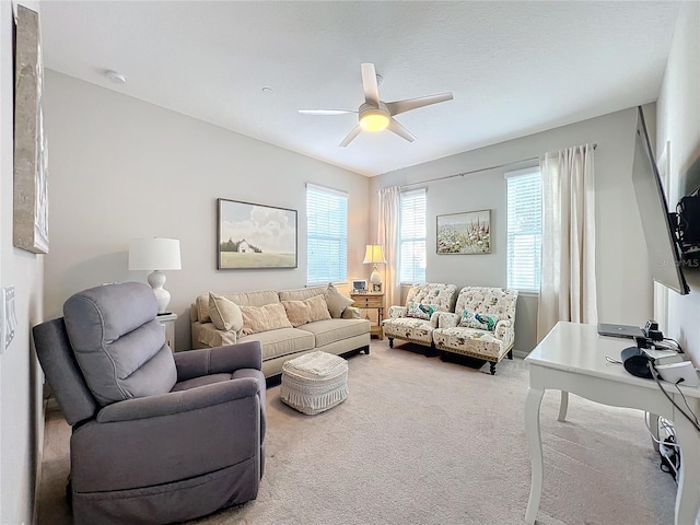 carpeted living room with ceiling fan