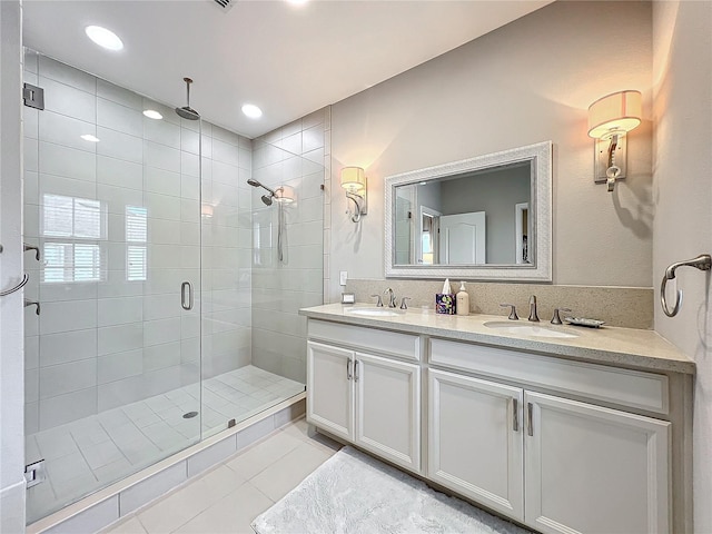 bathroom with tile patterned flooring, vanity, and walk in shower