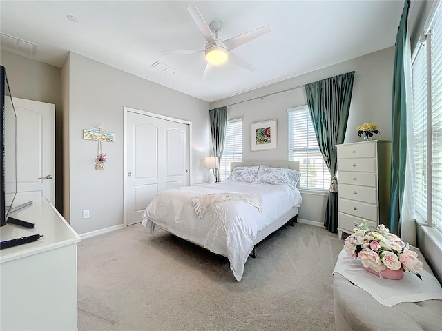 bedroom featuring light carpet, a closet, and ceiling fan