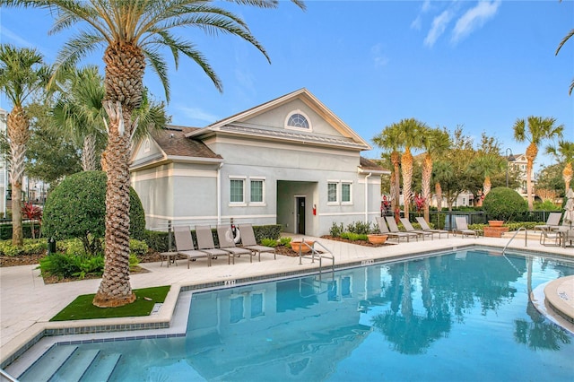 rear view of property featuring a patio area and a community pool