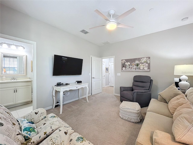 carpeted living room featuring ceiling fan and sink