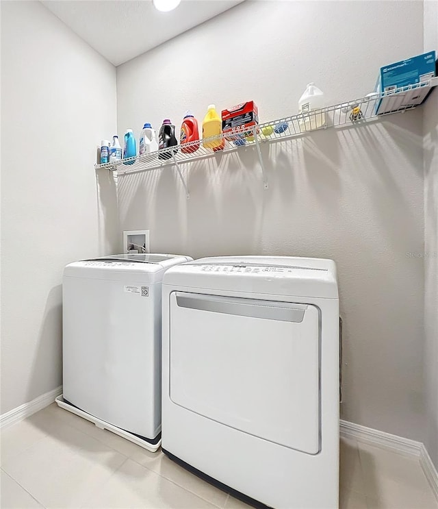 laundry room featuring separate washer and dryer and tile patterned flooring