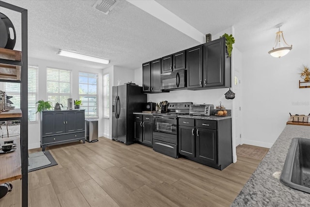 kitchen featuring light stone counters, pendant lighting, a textured ceiling, light hardwood / wood-style floors, and black appliances