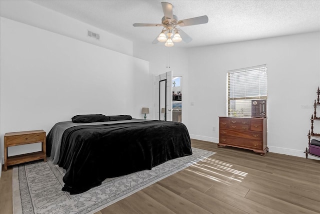 bedroom featuring a textured ceiling, hardwood / wood-style flooring, and ceiling fan