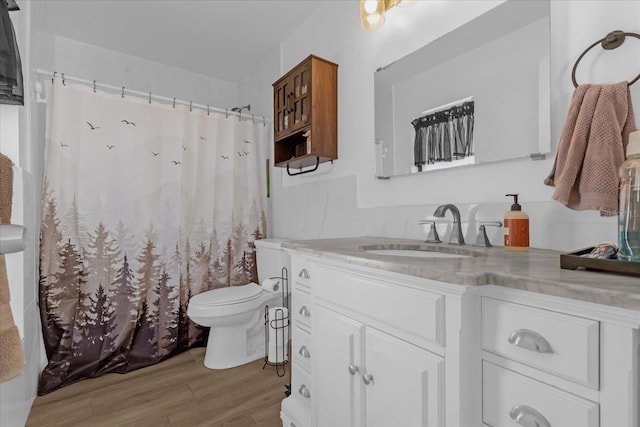 bathroom featuring vanity, wood-type flooring, and toilet