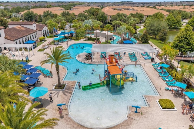 view of pool with a playground, a pergola, and a water slide