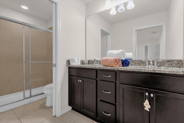 bathroom featuring tile patterned floors, vanity, toilet, and an enclosed shower