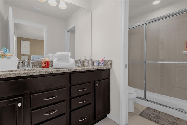 bathroom featuring toilet, vanity, tile patterned floors, and a shower with shower door