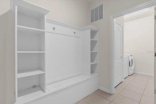 mudroom featuring independent washer and dryer and light tile patterned floors