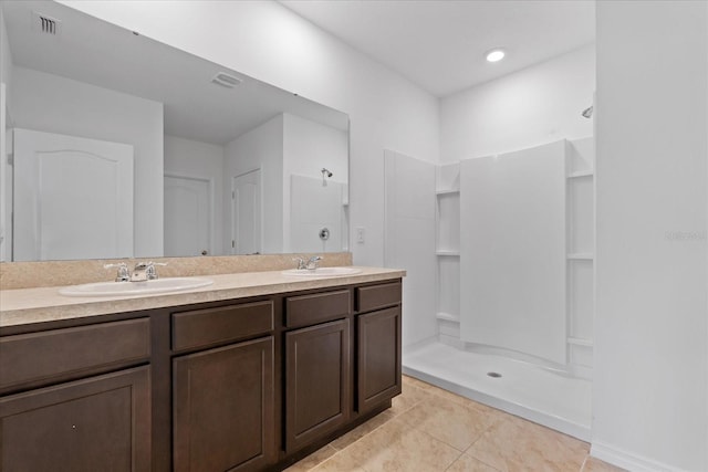 bathroom featuring tile patterned flooring, vanity, and walk in shower