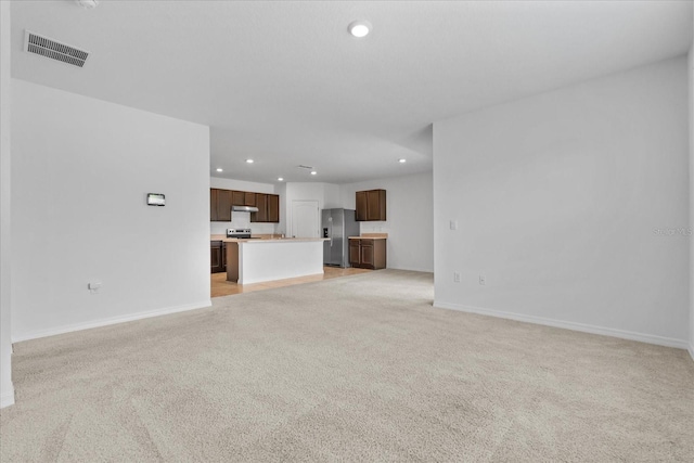 unfurnished living room with light colored carpet