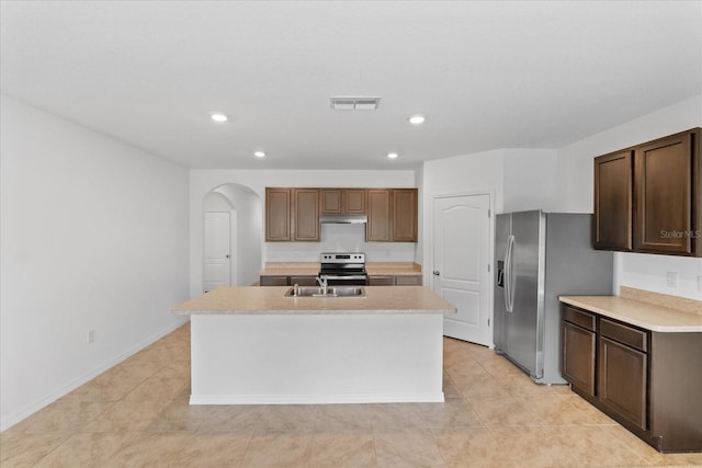 kitchen with a center island with sink, light tile patterned flooring, sink, and stainless steel appliances