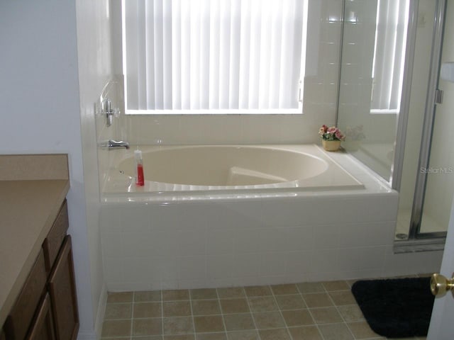 bathroom featuring tiled bath and vanity