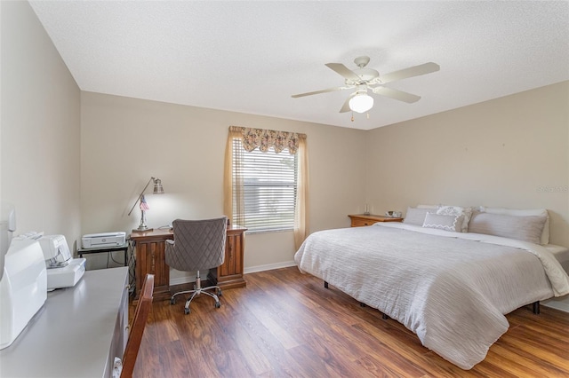 bedroom with ceiling fan, dark wood-type flooring, and a textured ceiling