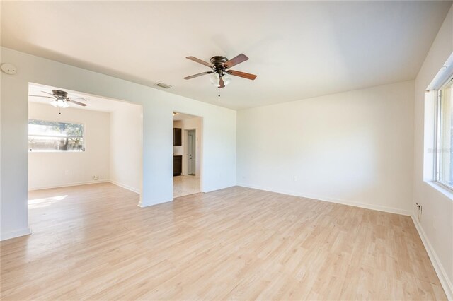 unfurnished room with ceiling fan, light hardwood / wood-style floors, and a wealth of natural light