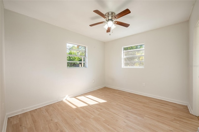 empty room featuring a wealth of natural light, light hardwood / wood-style flooring, and ceiling fan