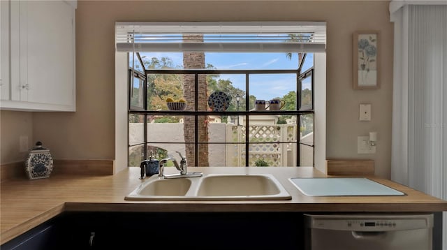 kitchen featuring dishwasher, white cabinets, plenty of natural light, and sink