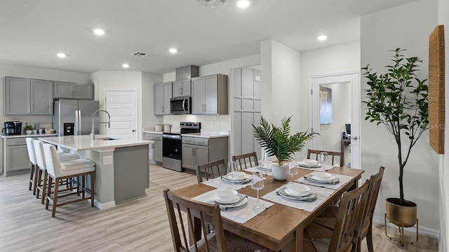 dining space with sink and light hardwood / wood-style flooring