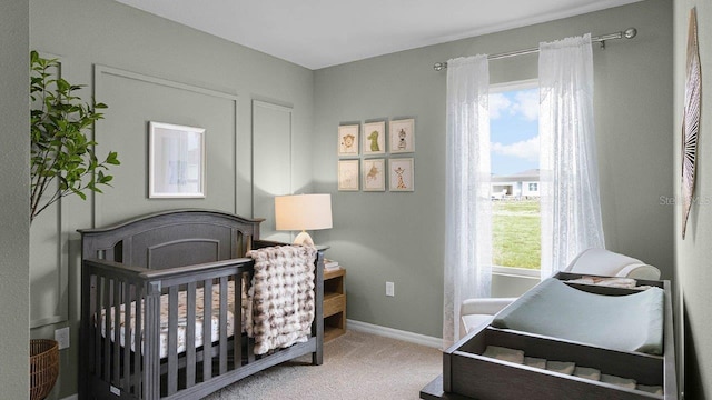 bedroom featuring a crib and carpet flooring