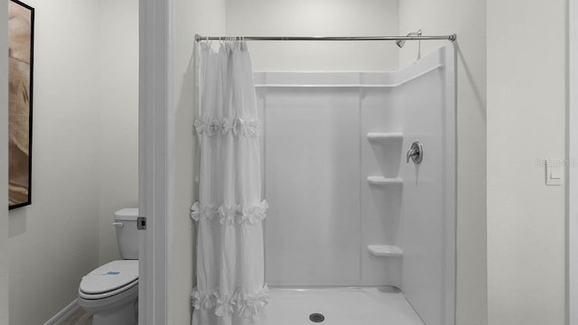 bathroom featuring a shower with curtain and toilet