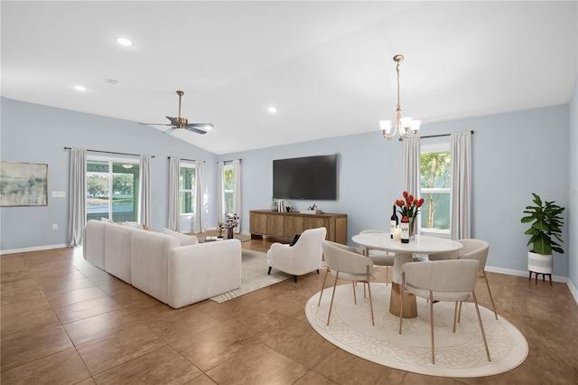 tiled living room with lofted ceiling, plenty of natural light, and ceiling fan with notable chandelier