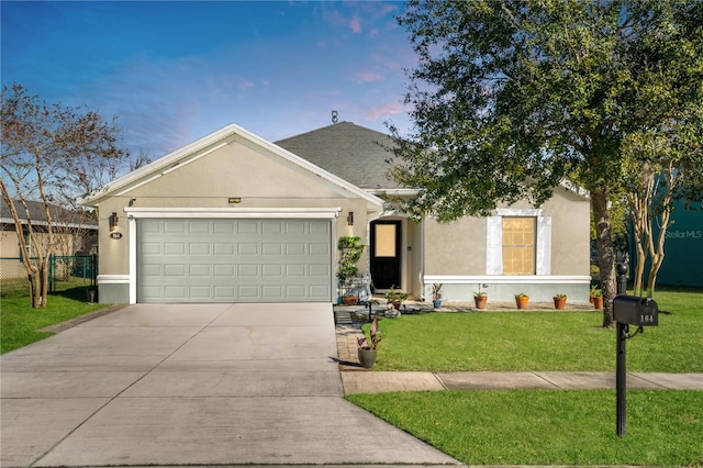 ranch-style home featuring stucco siding, fence, concrete driveway, an attached garage, and a front yard