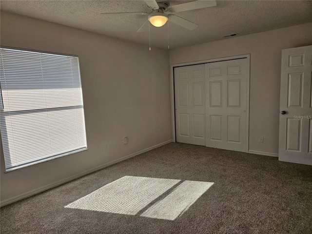 unfurnished bedroom with ceiling fan, a closet, carpet floors, and a textured ceiling