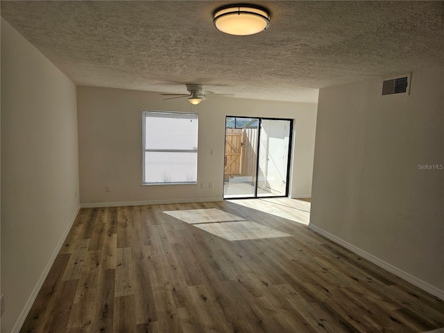 unfurnished room with ceiling fan, wood-type flooring, and a textured ceiling