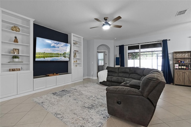 living room featuring a textured ceiling, built in features, ceiling fan, and light tile patterned flooring