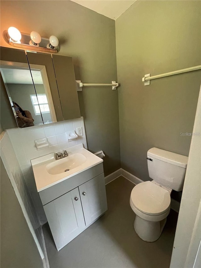 bathroom with vanity, toilet, and decorative backsplash