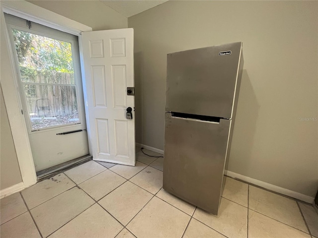 doorway to outside with light tile patterned flooring