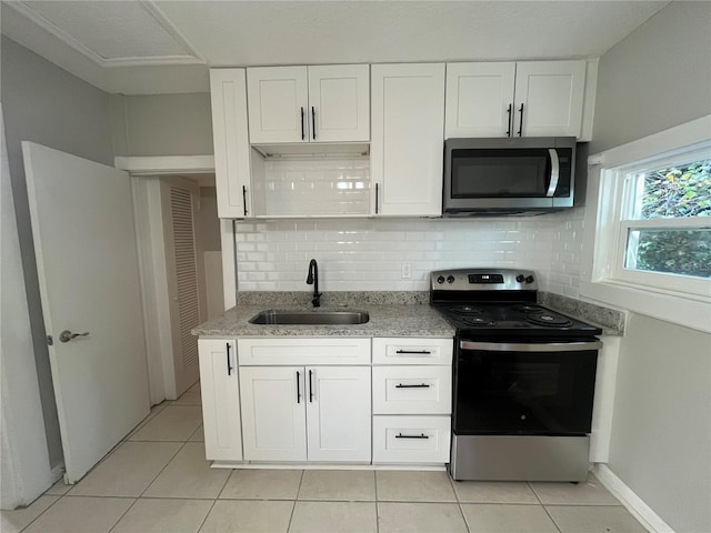 kitchen with white cabinetry, appliances with stainless steel finishes, sink, and light tile patterned flooring