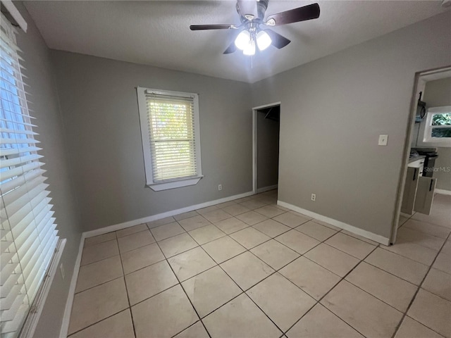 tiled empty room featuring ceiling fan