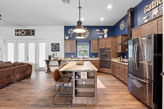 kitchen with double wall oven, freestanding refrigerator, a center island, open shelves, and pendant lighting