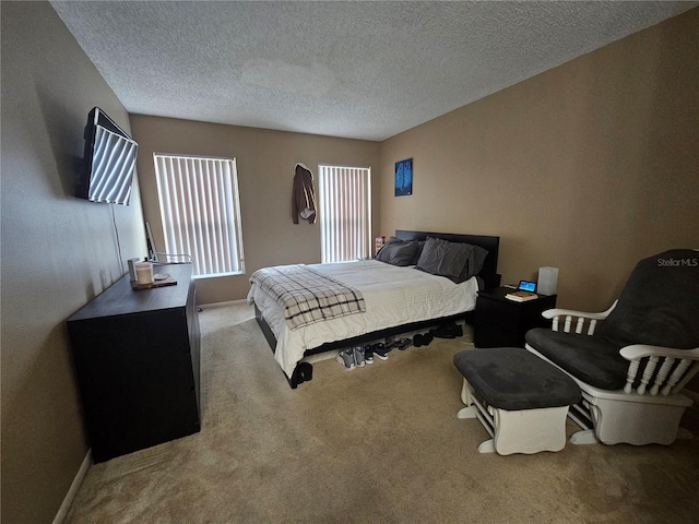 bedroom with a textured ceiling and light colored carpet