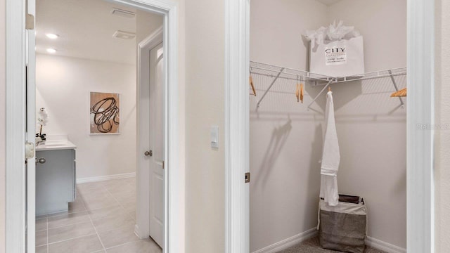 walk in closet with light tile patterned floors