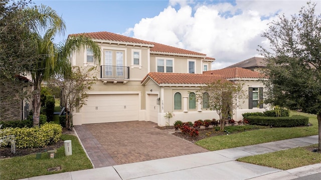 mediterranean / spanish home with a garage, a balcony, and a front lawn