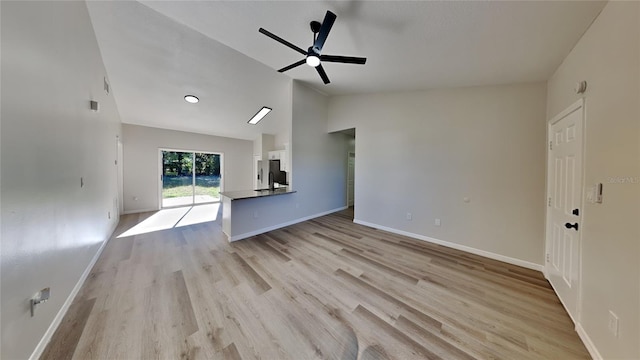 unfurnished living room featuring ceiling fan, light hardwood / wood-style floors, and vaulted ceiling