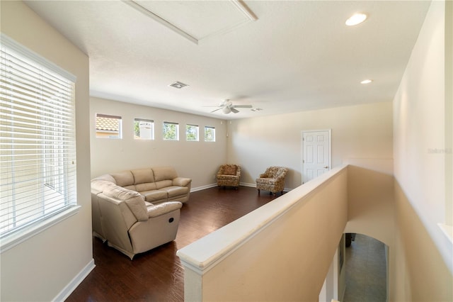 living room featuring ceiling fan and dark hardwood / wood-style floors