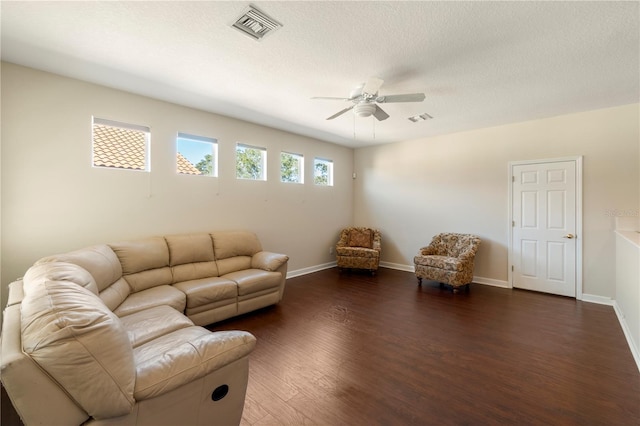 living room with ceiling fan, dark hardwood / wood-style floors, and a textured ceiling