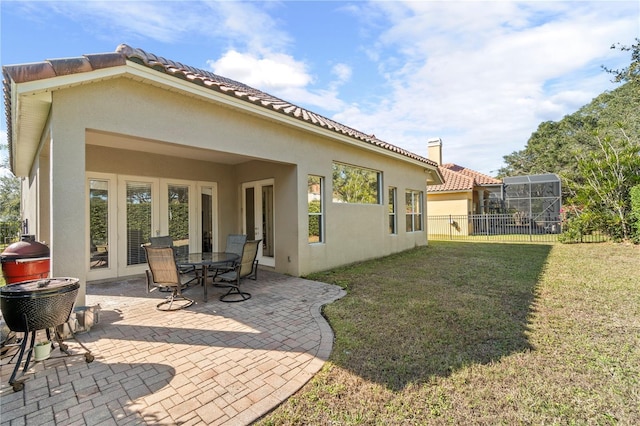 rear view of house featuring a patio area and a yard