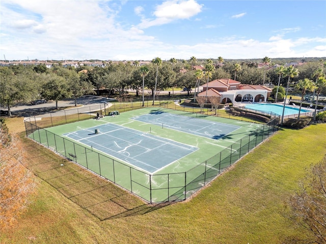 view of tennis court with a lawn