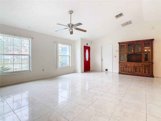 unfurnished living room featuring ceiling fan, light tile patterned floors, and vaulted ceiling