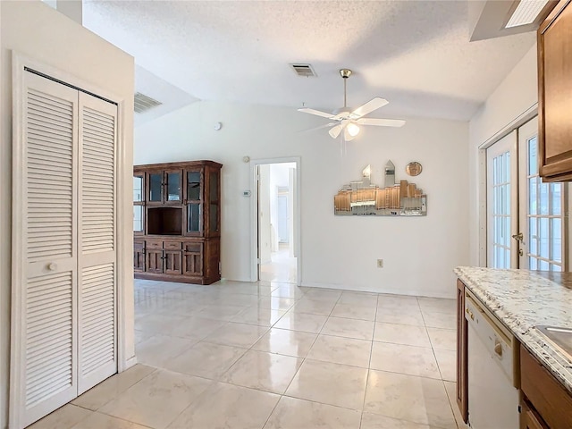 kitchen featuring ceiling fan, french doors, dishwasher, lofted ceiling, and a textured ceiling