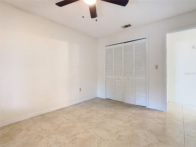 unfurnished bedroom featuring ceiling fan and a closet