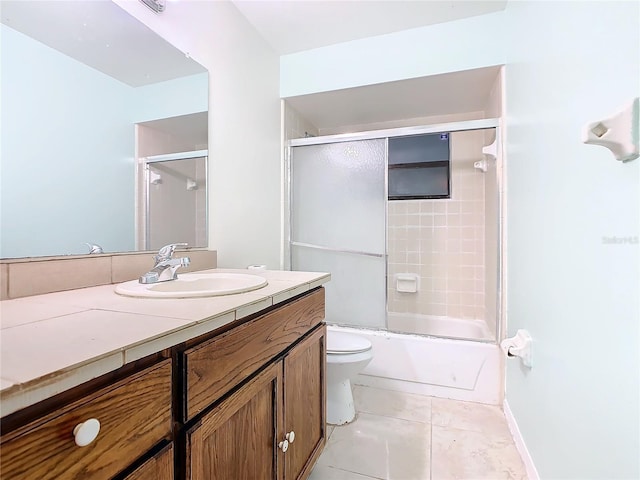 full bathroom with toilet, vanity, tile patterned floors, and bath / shower combo with glass door