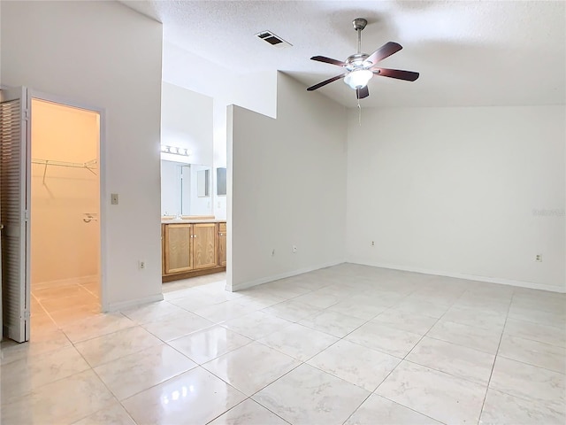 tiled spare room with ceiling fan and a textured ceiling